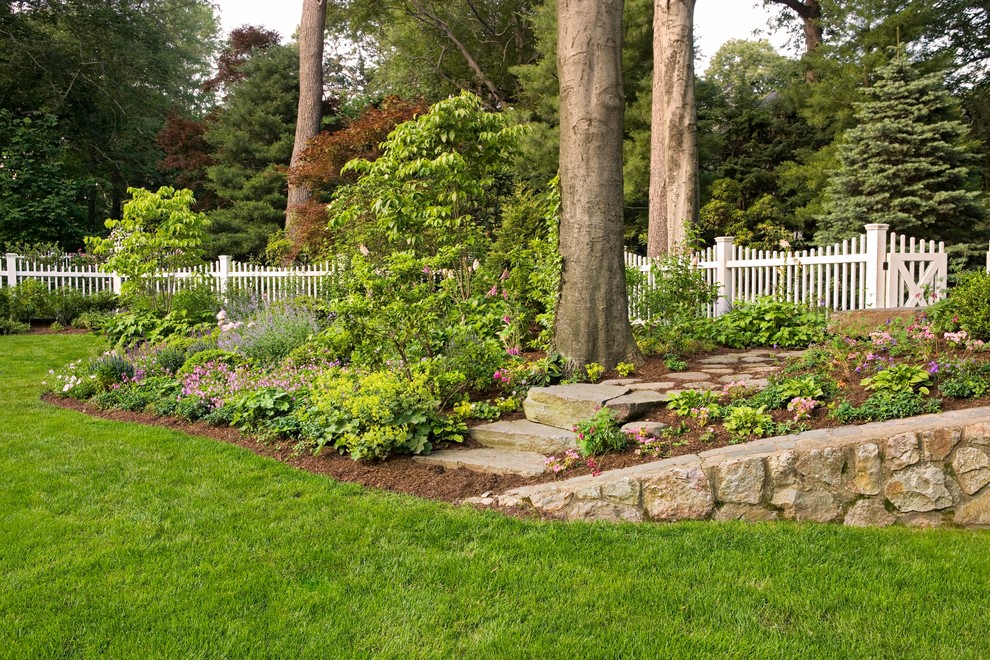Photo of a traditional backyard garden in New York with natural stone pavers.