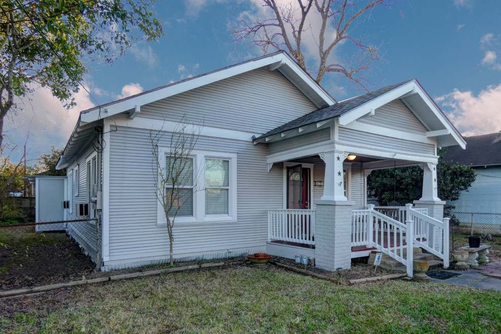 Kleines, Einstöckiges Uriges Haus mit grauer Fassadenfarbe, Satteldach, Schindeldach, grauem Dach und Verschalung in Houston