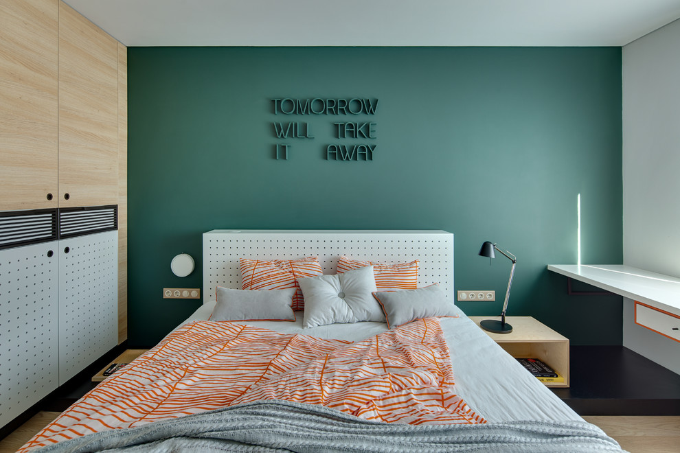 Contemporary master bedroom in Other with green walls and light hardwood floors.