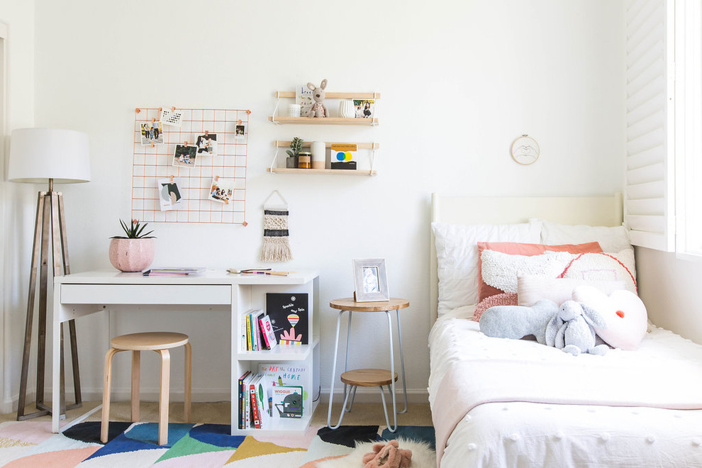 Photo of a small scandinavian kids' room for girls in San Francisco with white walls, carpet and beige floor.