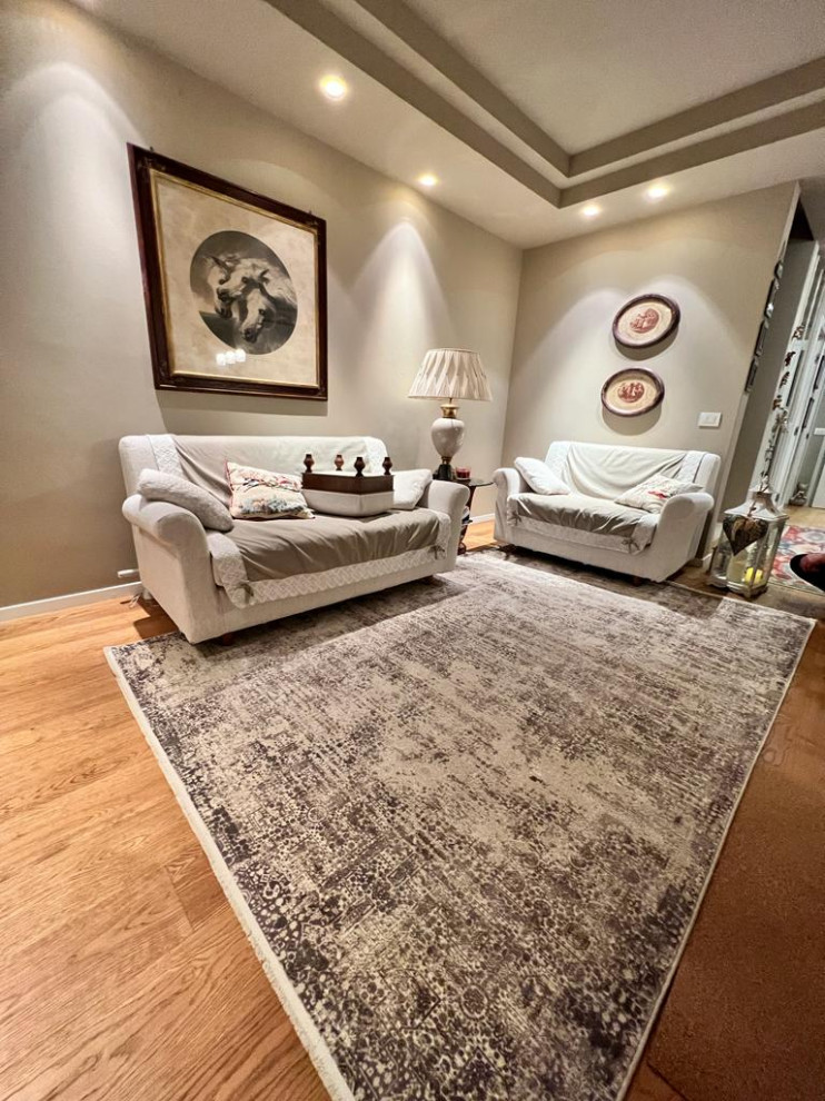 Diseño de salón abierto actual de tamaño medio con paredes beige, suelo de madera en tonos medios, televisor independiente, bandeja y alfombra