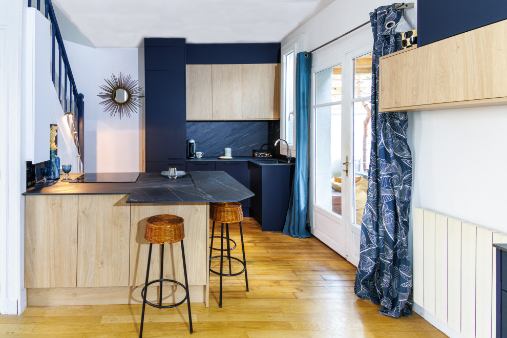 Foto de cocina contemporánea con puertas de armario de madera clara, salpicadero verde y encimeras grises