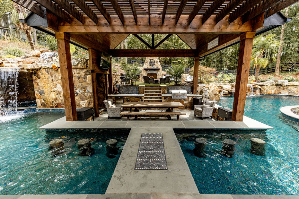 This is an example of a large traditional back swimming pool in Atlanta with a pool house.