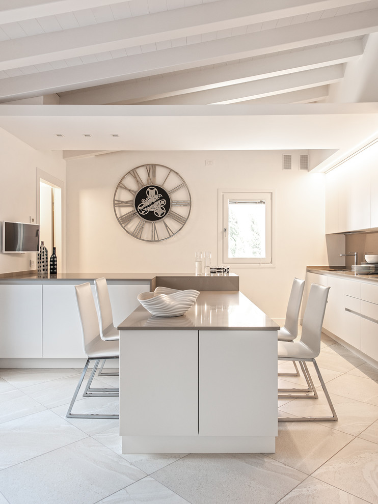 Design ideas for a large contemporary single-wall eat-in kitchen in Milan with flat-panel cabinets, white cabinets, solid surface benchtops, beige splashback and a peninsula.