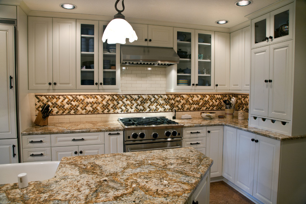 Photo of a large traditional l-shaped eat-in kitchen in Seattle with a farmhouse sink, raised-panel cabinets, white cabinets, granite benchtops, multi-coloured splashback, mosaic tile splashback, panelled appliances, with island and concrete floors.