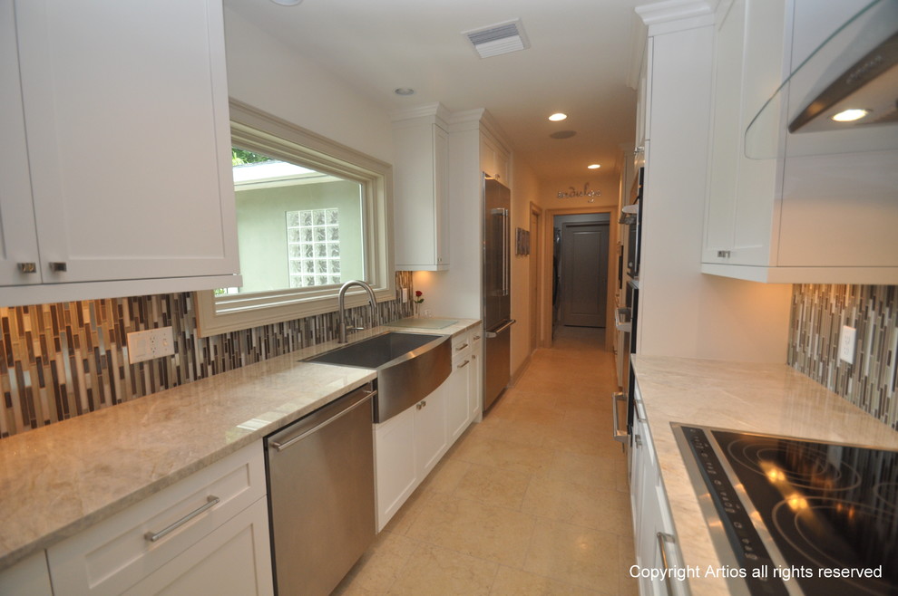 Example of a transitional galley eat-in kitchen design in Orlando with a farmhouse sink, shaker cabinets, white cabinets, granite countertops, multicolored backsplash and stainless steel appliances