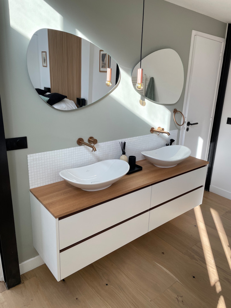 Идея дизайна: ванная комната в современном стиле с белыми фасадами, накладной ванной, светлым паркетным полом, накладной раковиной, тумбой под две раковины и подвесной тумбой