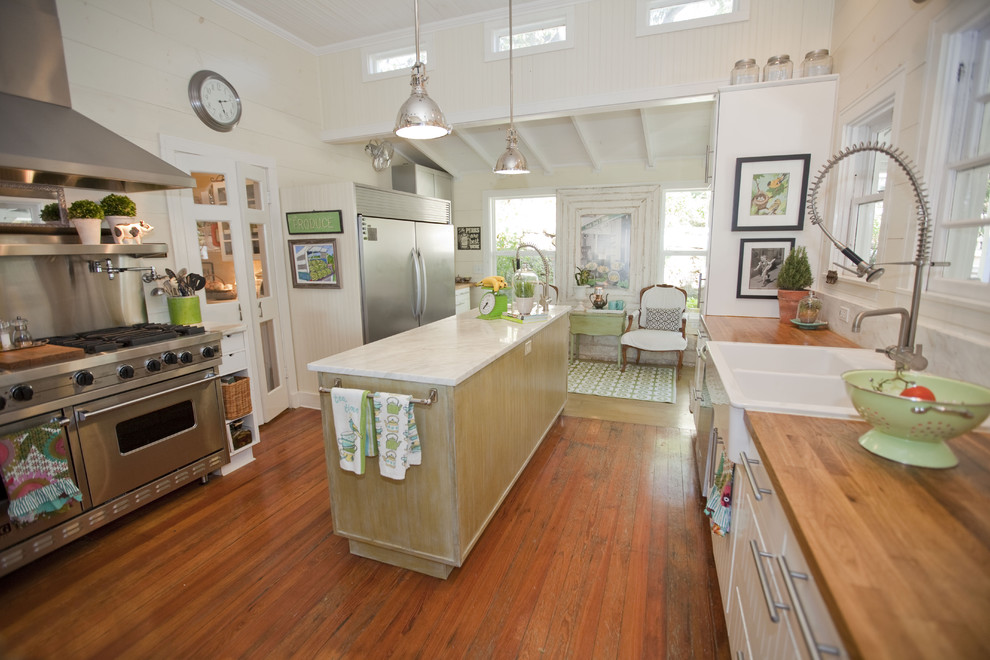 Country separate kitchen in Austin with stainless steel appliances, a double-bowl sink and wood benchtops.