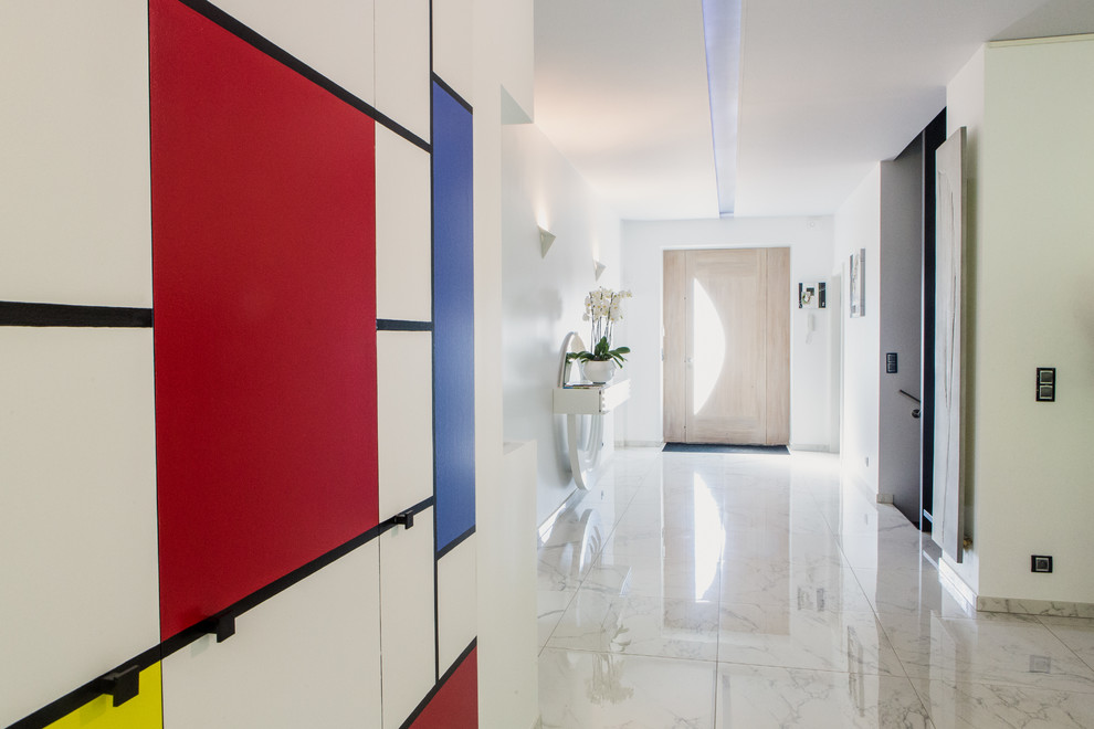 This is an example of a large contemporary foyer in Strasbourg with multi-coloured walls and marble floors.