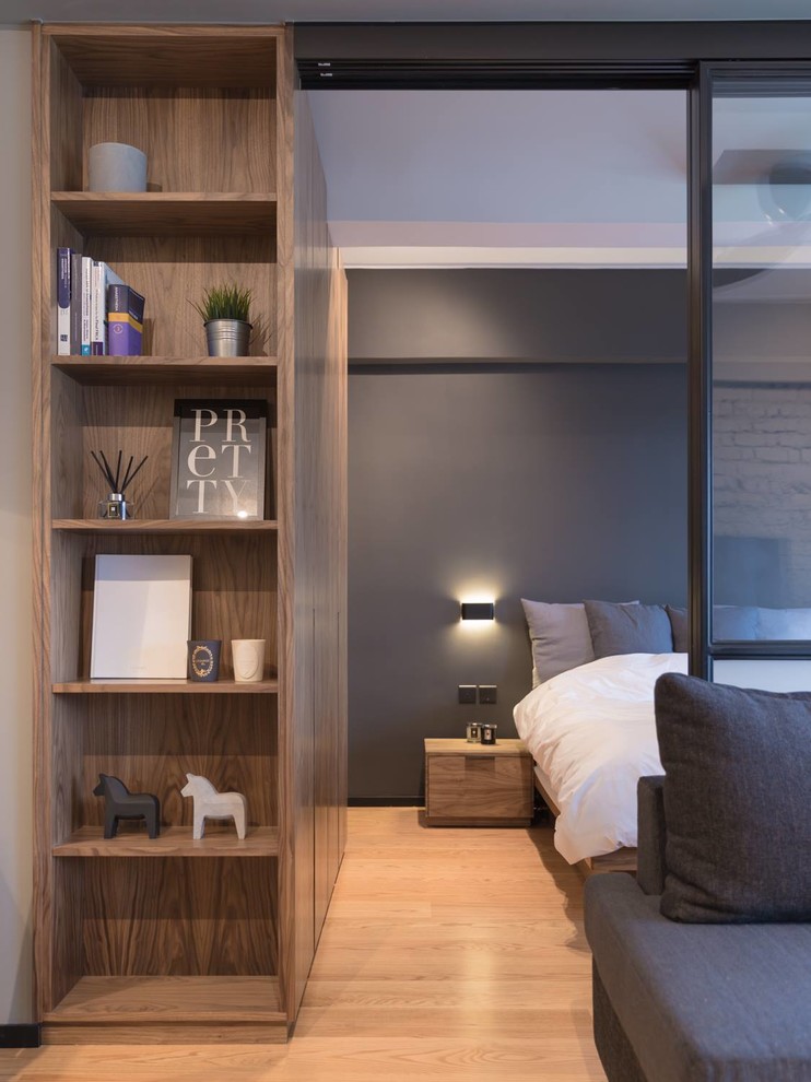 This is an example of a small industrial master bedroom in Hong Kong with grey walls and plywood floors.