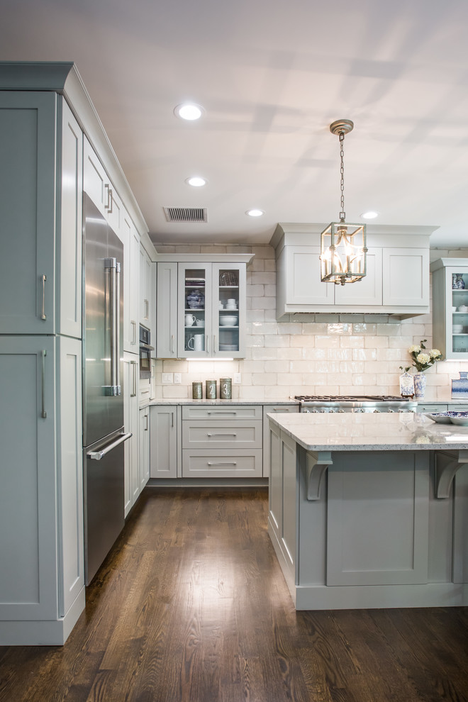 Transitional u-shaped eat-in kitchen in Charlotte with shaker cabinets, grey cabinets, white splashback, subway tile splashback, stainless steel appliances, medium hardwood floors, with island, brown floor and white benchtop.