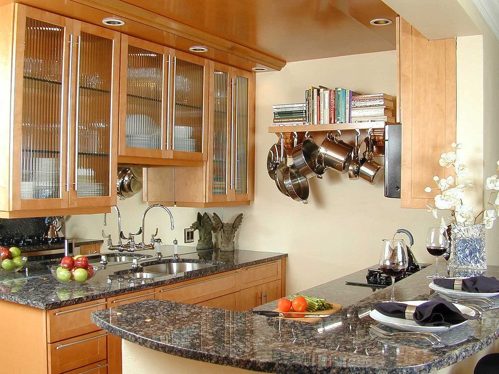 Small transitional galley ceramic tile kitchen photo in Miami with an undermount sink, shaker cabinets, medium tone wood cabinets, granite countertops, mirror backsplash and stainless steel appliances