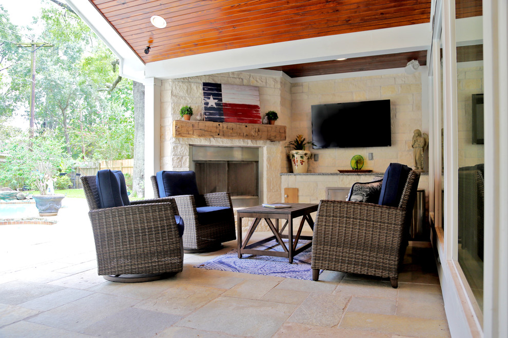 Photo of a mid-sized country backyard patio in Other with with fireplace, natural stone pavers and a roof extension.