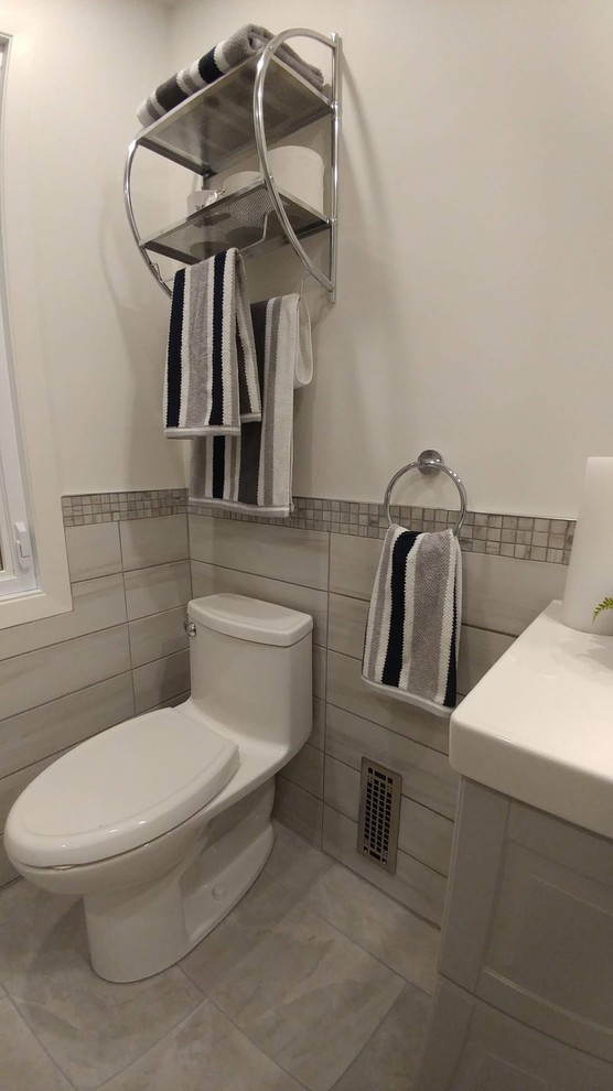 Small contemporary master bathroom in Montreal with shaker cabinets, grey cabinets, an alcove tub, a shower/bathtub combo, a one-piece toilet, gray tile, ceramic tile, white walls, ceramic floors, an integrated sink, grey floor, a hinged shower door and white benchtops.