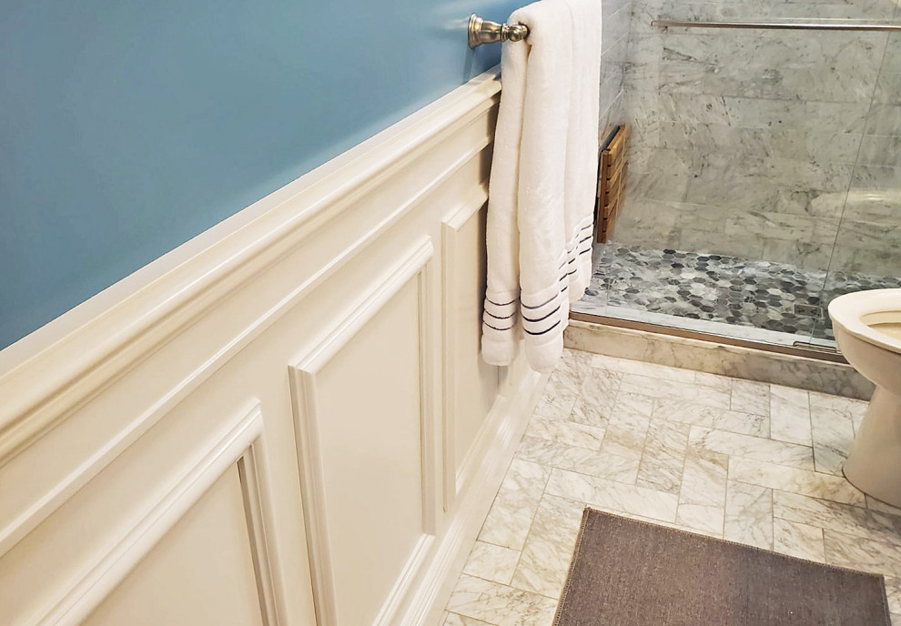 This is an example of a small contemporary bathroom in Boston with white cabinets, a one-piece toilet, gray tile, marble, blue walls, marble floors, grey floor, a sliding shower screen, white benchtops, a shower seat, a single vanity and decorative wall panelling.