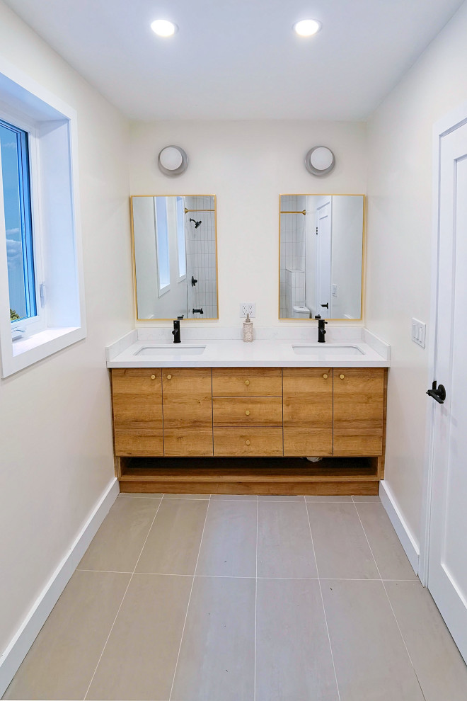This is an example of a mid-sized modern 3/4 bathroom in Toronto with flat-panel cabinets, brown cabinets, an alcove tub, a shower/bathtub combo, a two-piece toilet, white tile, porcelain tile, white walls, ceramic floors, an undermount sink, quartzite benchtops, grey floor, a shower curtain, white benchtops, a double vanity and a built-in vanity.