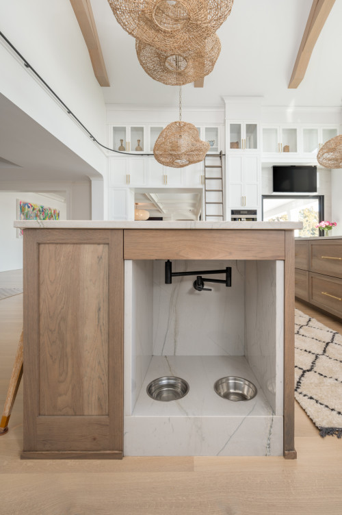 Built-in dog feeding station with stainless steel bowls and pot filler in a modern kitchen island