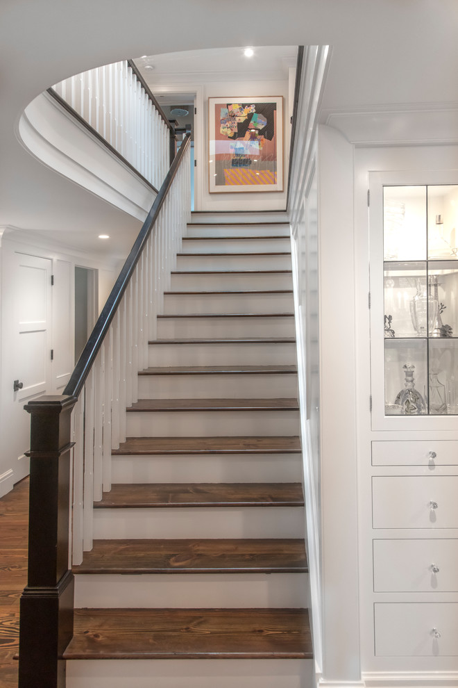 This is an example of a mid-sized transitional wood straight staircase in Detroit with painted wood risers and wood railing.