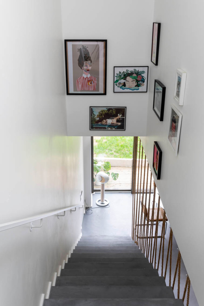 Источник вдохновения для домашнего уюта: прямая бетонная лестница среднего размера с бетонными ступенями, перилами из тросов и кладовкой или шкафом под ней
