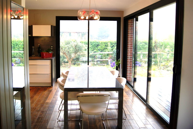 Large contemporary open plan dining in Le Havre with bamboo floors, white walls and brown floor.