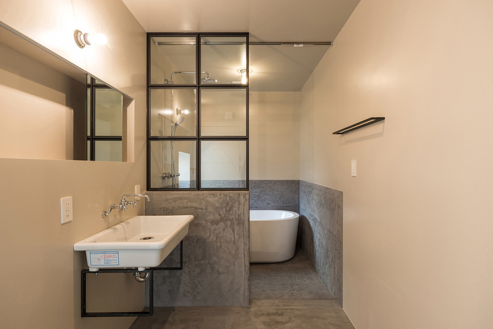 Inspiration for a beach style bathroom in Yokohama with a freestanding tub, white walls, concrete floors, a wall-mount sink and an open shower.