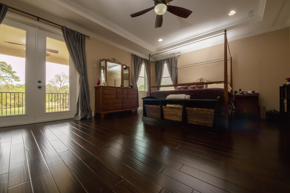 Large traditional master bedroom in Orlando with dark hardwood floors.