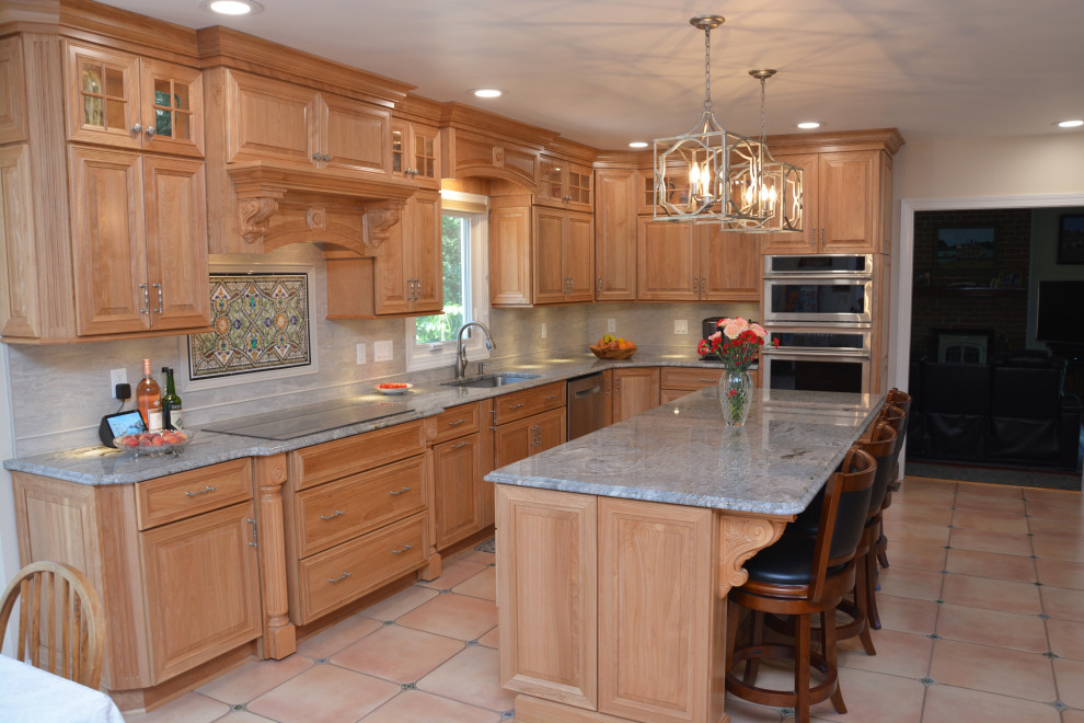 This is an example of a large classic l-shaped kitchen/diner in DC Metro with a submerged sink, raised-panel cabinets, light wood cabinets, granite worktops, grey splashback, stainless steel appliances, an island, beige floors and blue worktops.
