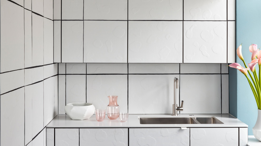 Offene, Einzeilige, Kleine Moderne Küche mit Waschbecken, weißen Schränken, Küchenrückwand in Weiß, Rückwand aus Porzellanfliesen und weißer Arbeitsplatte in München