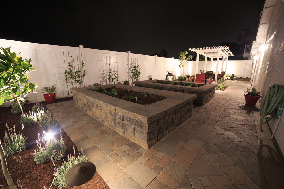 Small transitional backyard patio in San Diego with a vegetable garden, concrete pavers and a pergola.