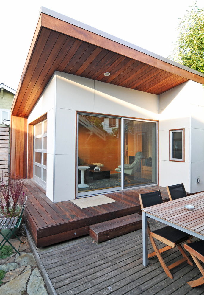 This is an example of a mid-sized modern one-storey white house exterior in Seattle with a shed roof.