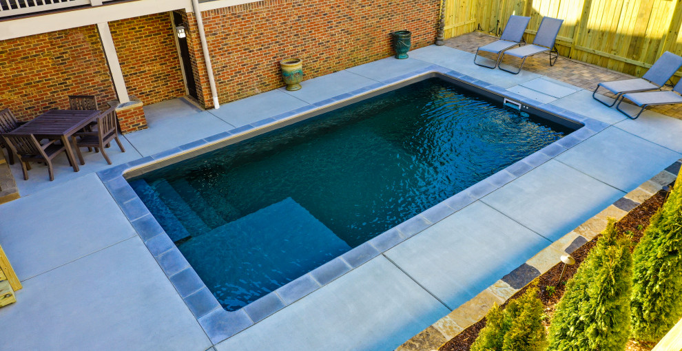 Imagen de piscina pequeña rectangular en patio trasero con losas de hormigón
