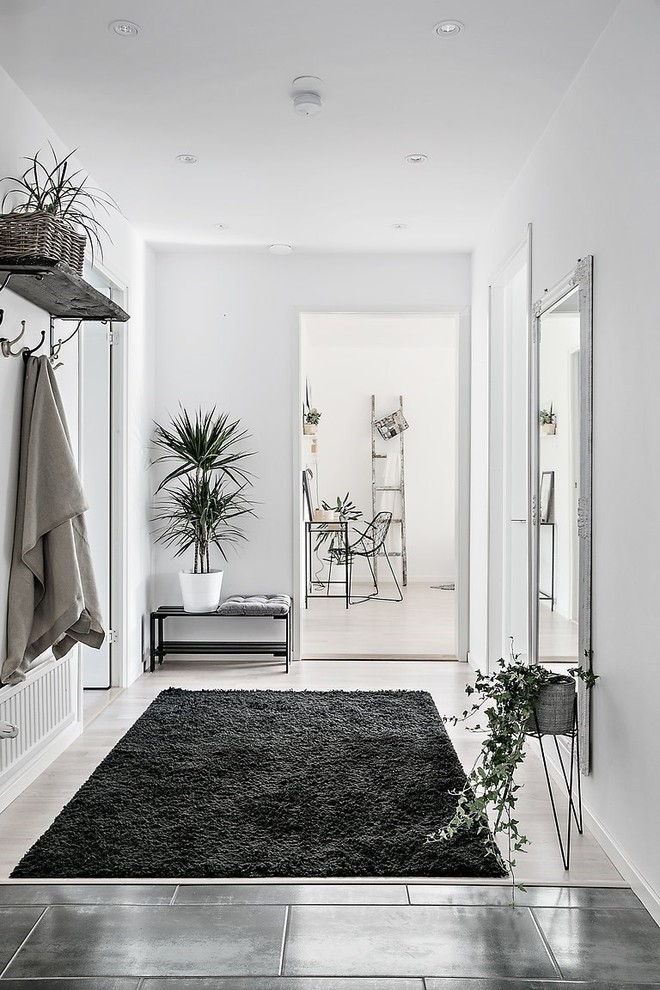 Photo of a mid-sized scandinavian vestibule in Gothenburg with white walls, light hardwood floors and a single front door.