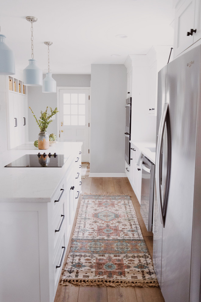 Moderne Küche mit Unterbauwaschbecken, weißen Schränken, Quarzit-Arbeitsplatte, Rückwand aus Marmor, Küchengeräten aus Edelstahl und Kücheninsel in Indianapolis