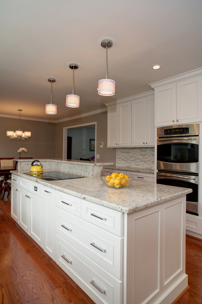 Eat-in kitchen - mid-sized transitional u-shaped medium tone wood floor eat-in kitchen idea in DC Metro with a single-bowl sink, beaded inset cabinets, white cabinets, quartz countertops, white backsplash, matchstick tile backsplash, stainless steel appliances and an island