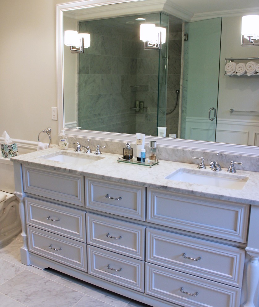 This is an example of a large contemporary master bathroom in Newark with beaded inset cabinets, white cabinets, a freestanding tub, a corner shower, gray tile, ceramic tile, white walls, ceramic floors and granite benchtops.