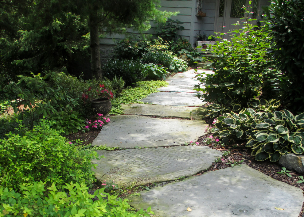 Inspiration for a mid-sized rustic shade front yard stone formal garden.