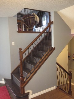 bent iron design interior railing with a distressed wood
