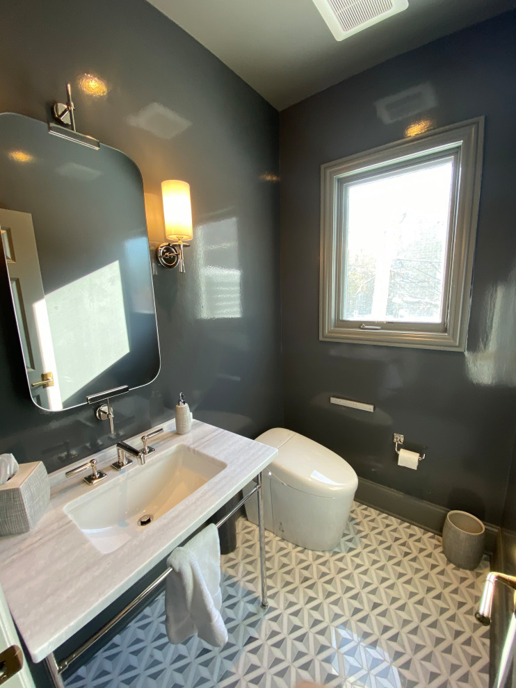Inspiration for a small traditional powder room in Chicago with open cabinets, grey cabinets, a one-piece toilet, blue walls, mosaic tile floors, a pedestal sink, marble benchtops, grey floor, grey benchtops, a freestanding vanity and wallpaper.