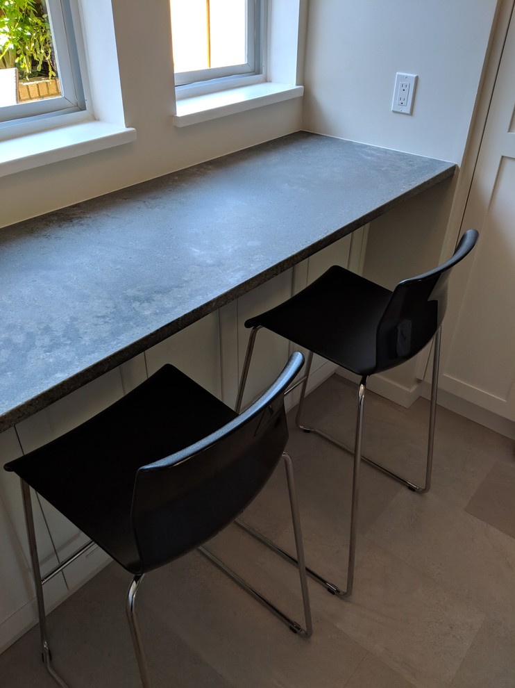 Example of a small transitional u-shaped vinyl floor and beige floor eat-in kitchen design in Vancouver with a single-bowl sink, shaker cabinets, white cabinets, quartz countertops, gray backsplash, ceramic backsplash, stainless steel appliances, no island and gray countertops