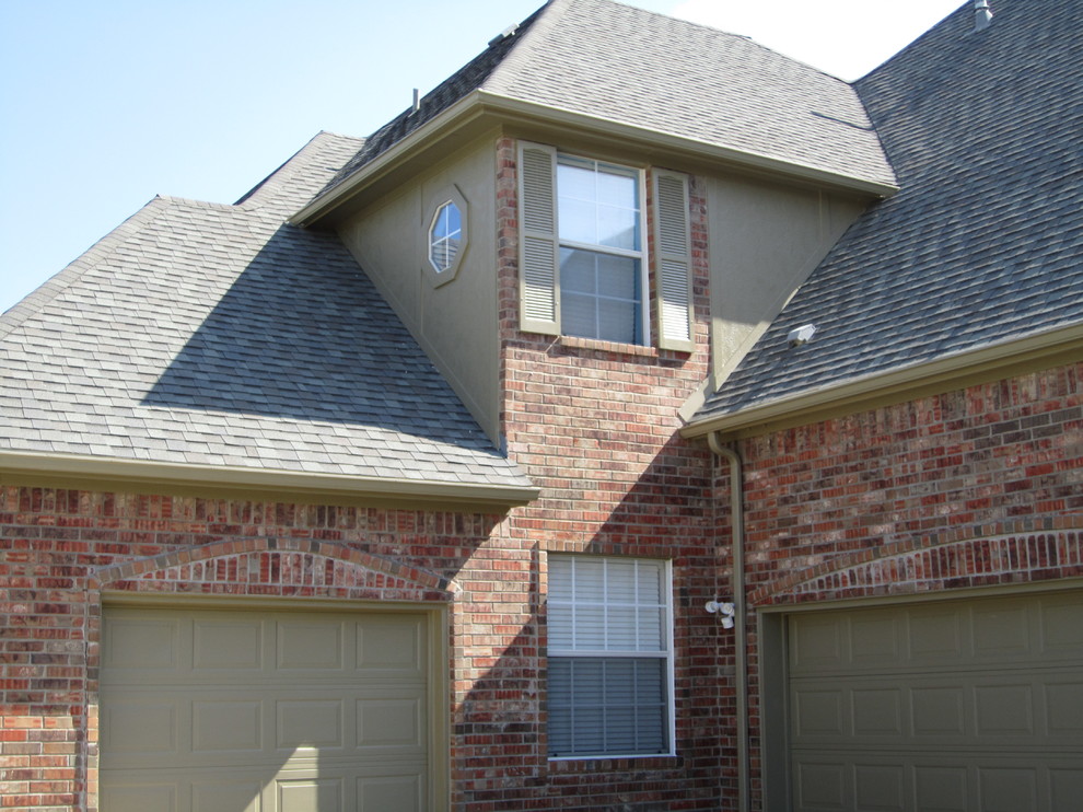Inspiration for a large traditional two-storey brick red house exterior in Dallas with a hip roof and a shingle roof.
