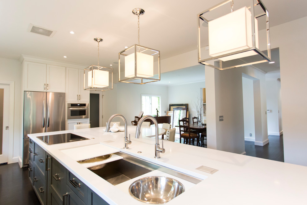 Kitchen - large transitional l-shaped dark wood floor and brown floor kitchen idea with an undermount sink, shaker cabinets, white cabinets, quartz countertops, white backsplash, stainless steel appliances, an island and white countertops