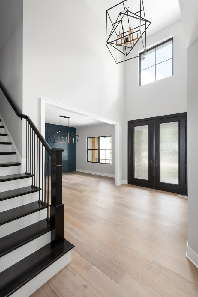 Inspiration for a large country foyer in Chicago with grey walls, light hardwood floors, a double front door, a glass front door and beige floor.