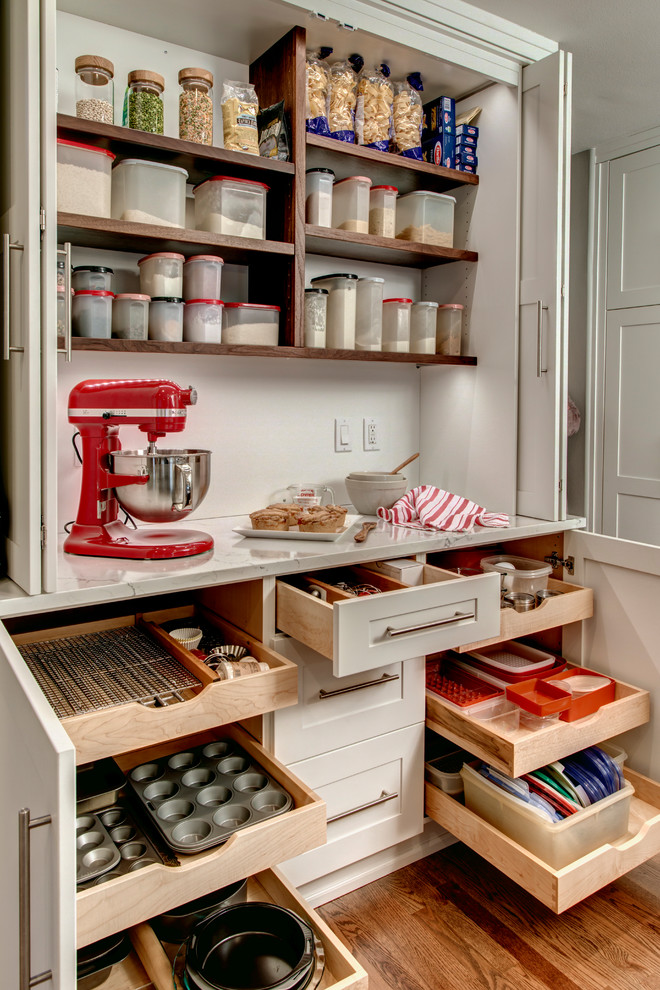 Mid-sized trendy galley medium tone wood floor home design photo in Seattle with an undermount sink, shaker cabinets, white cabinets, quartz countertops, gray backsplash, porcelain backsplash, stainless steel appliances and an island