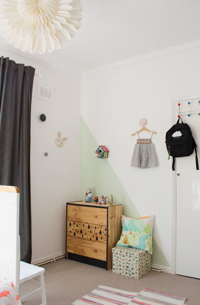 This is an example of a small scandinavian gender-neutral kids' bedroom for kids 4-10 years old in Kent with white walls and carpet.