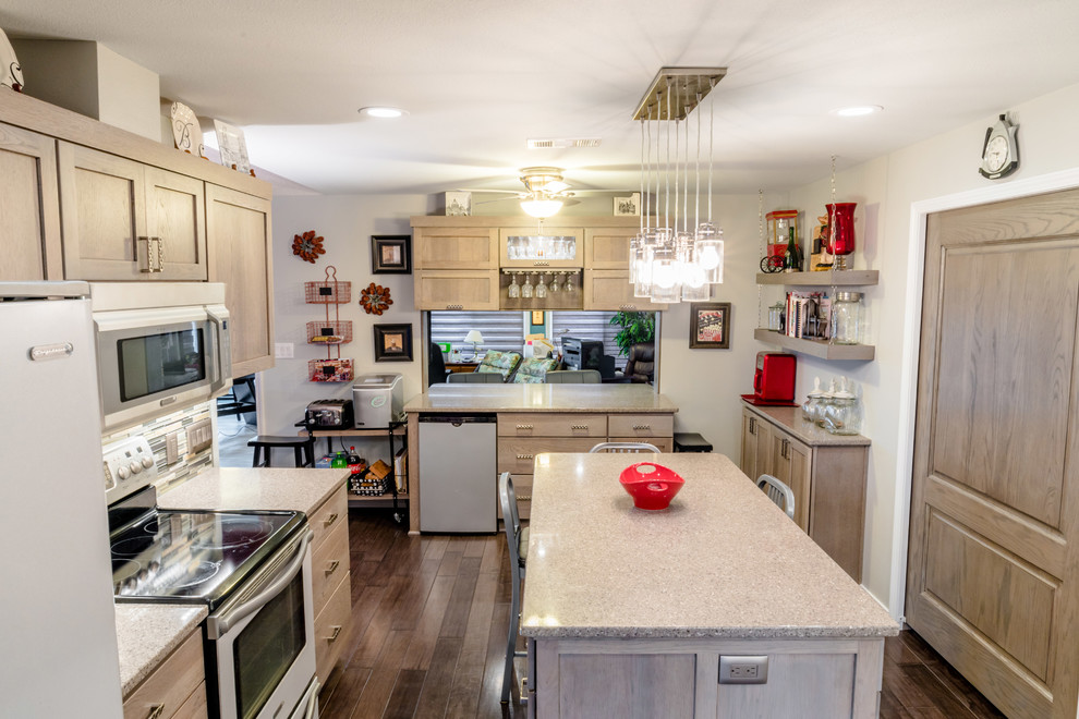 Inspiration for a mid-sized transitional u-shaped medium tone wood floor enclosed kitchen remodel in Miami with a farmhouse sink, shaker cabinets, gray cabinets, quartz countertops, gray backsplash, glass tile backsplash, white appliances and an island