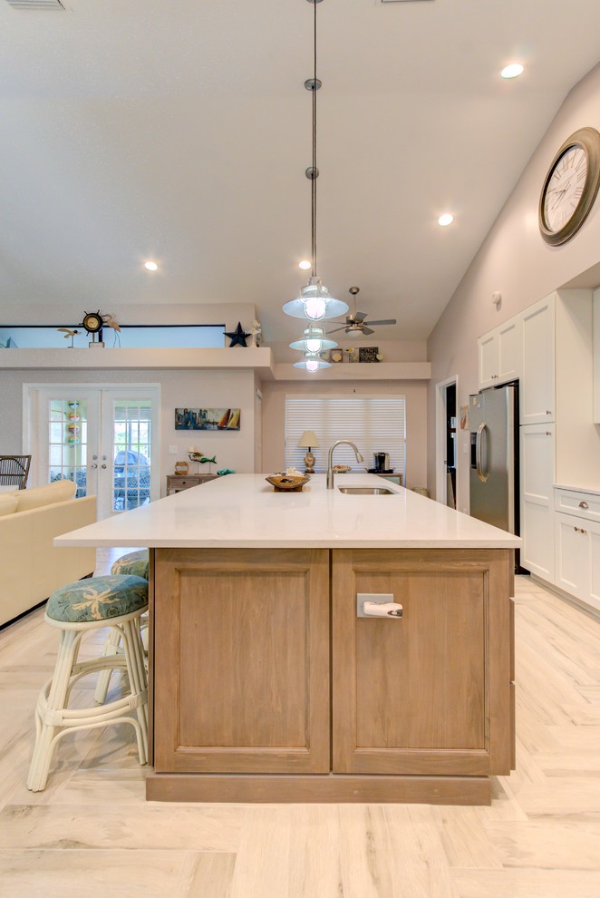 Open concept kitchen - large single-wall porcelain tile and white floor open concept kitchen idea with an undermount sink, shaker cabinets, white cabinets, quartz countertops, blue backsplash, stainless steel appliances, an island and white countertops