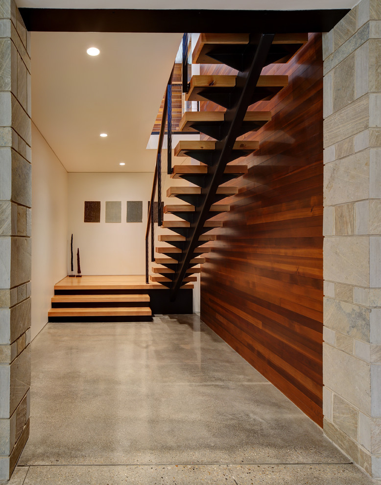 Design ideas for a mid-sized contemporary wood straight staircase in Milwaukee with open risers and cable railing.