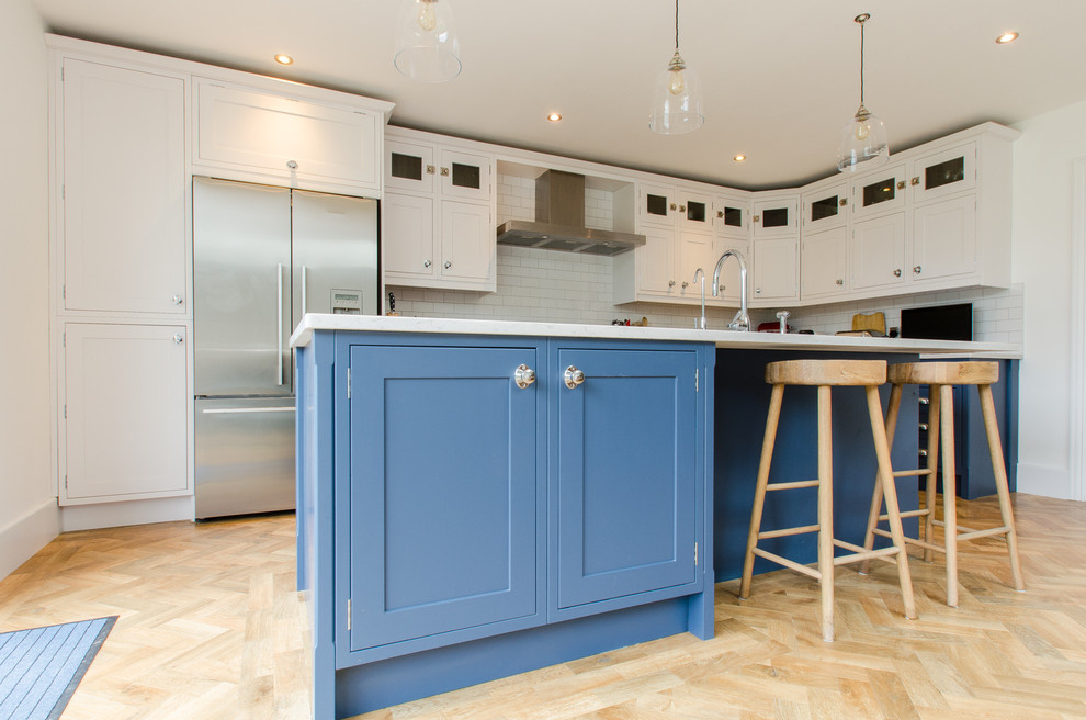 Inspiration for a large country l-shaped eat-in kitchen in Kent with an integrated sink, shaker cabinets, blue cabinets, quartzite benchtops, subway tile splashback, coloured appliances, medium hardwood floors and with island.