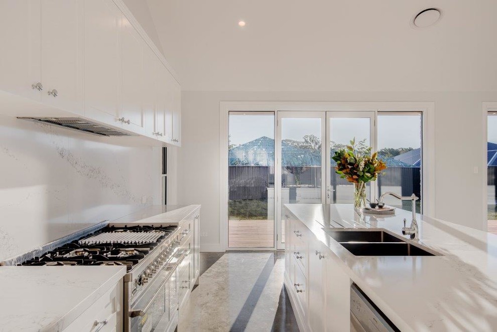 Design ideas for a contemporary eat-in kitchen in Sydney with a double-bowl sink, white cabinets, laminate benchtops, white splashback, stone slab splashback and stainless steel appliances.