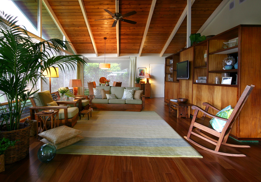 Design ideas for a mid-sized tropical enclosed family room in Hawaii with white walls, medium hardwood floors, no fireplace, a built-in media wall and beige floor.